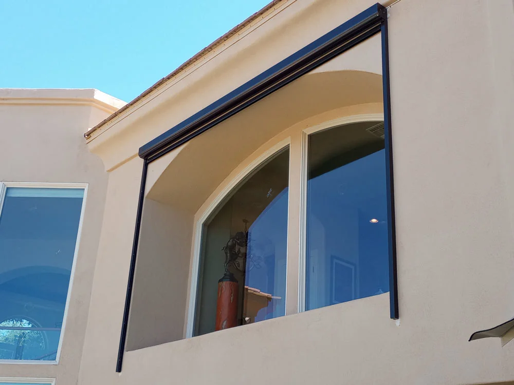 Rolling shutter housing installed above an arched home window