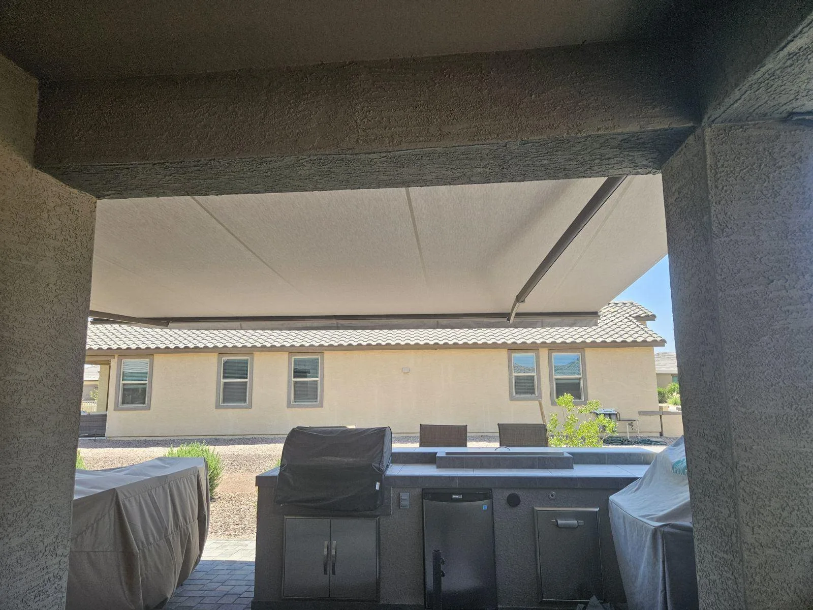 Retractable awning extended over a poolside patio