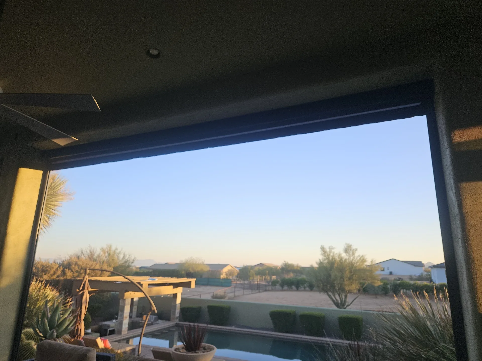 Exterior retractable shade partially lowered over a patio opening