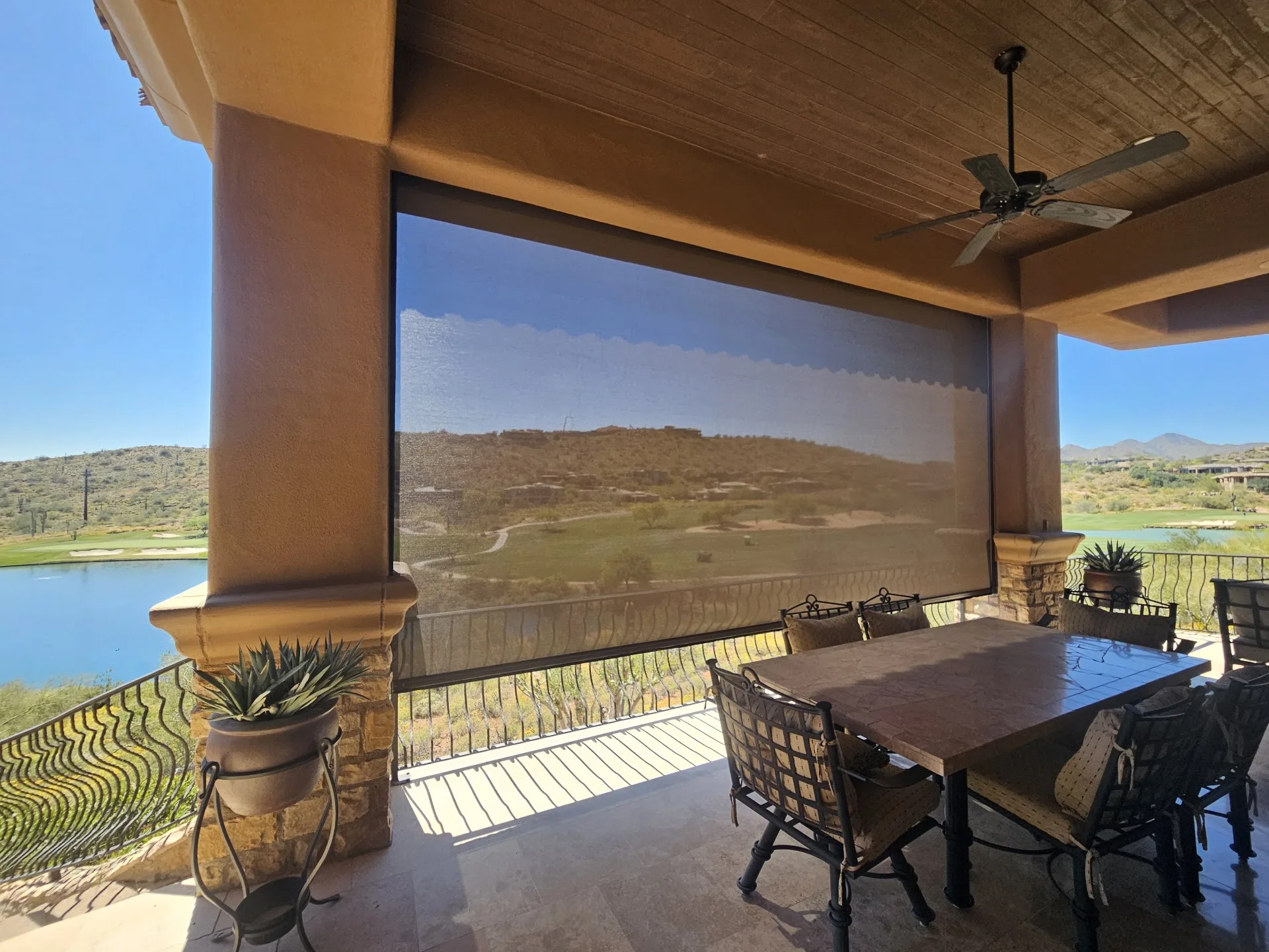 Covered patio with an exterior retractable shade screen lowered