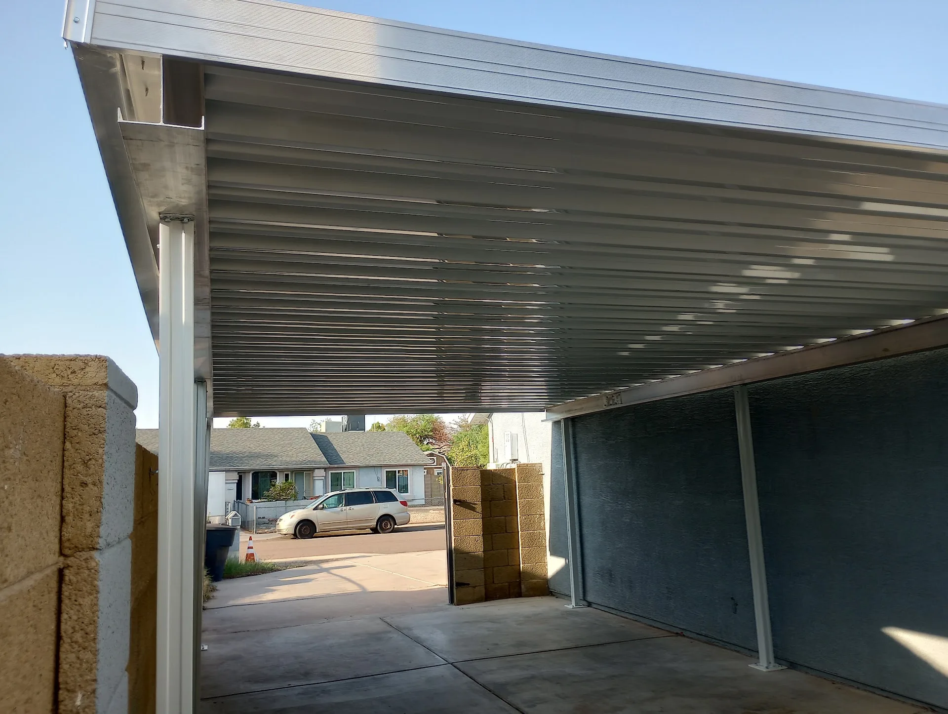 Metal carport structure covering a residential driveway
